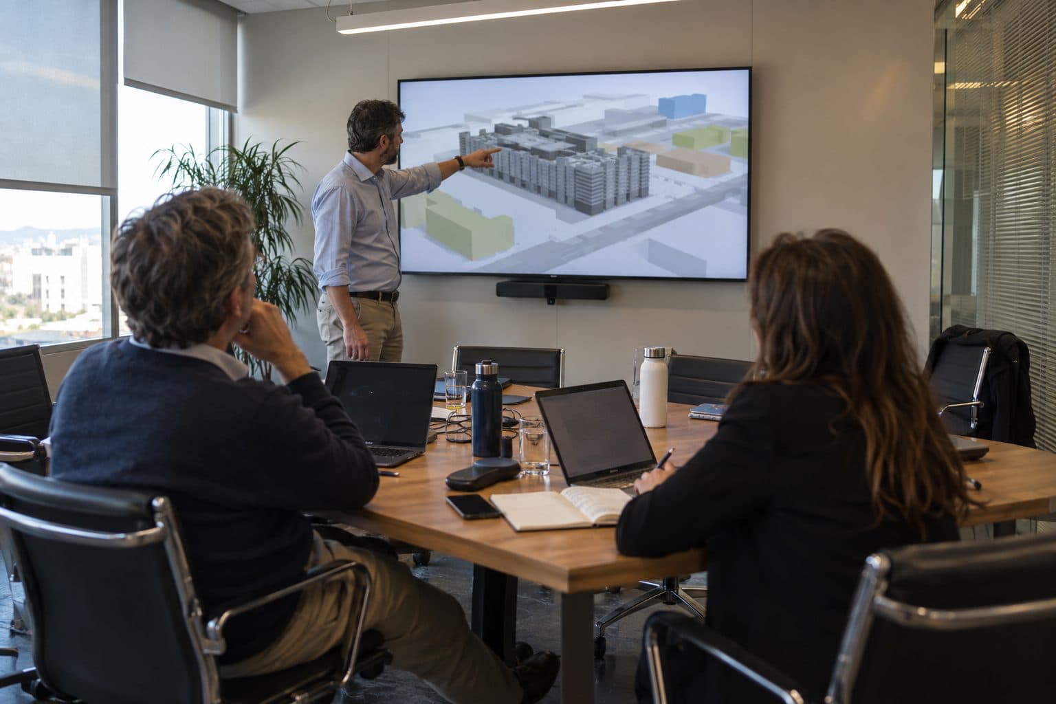 Advisory meeting reviewing a building model on screen